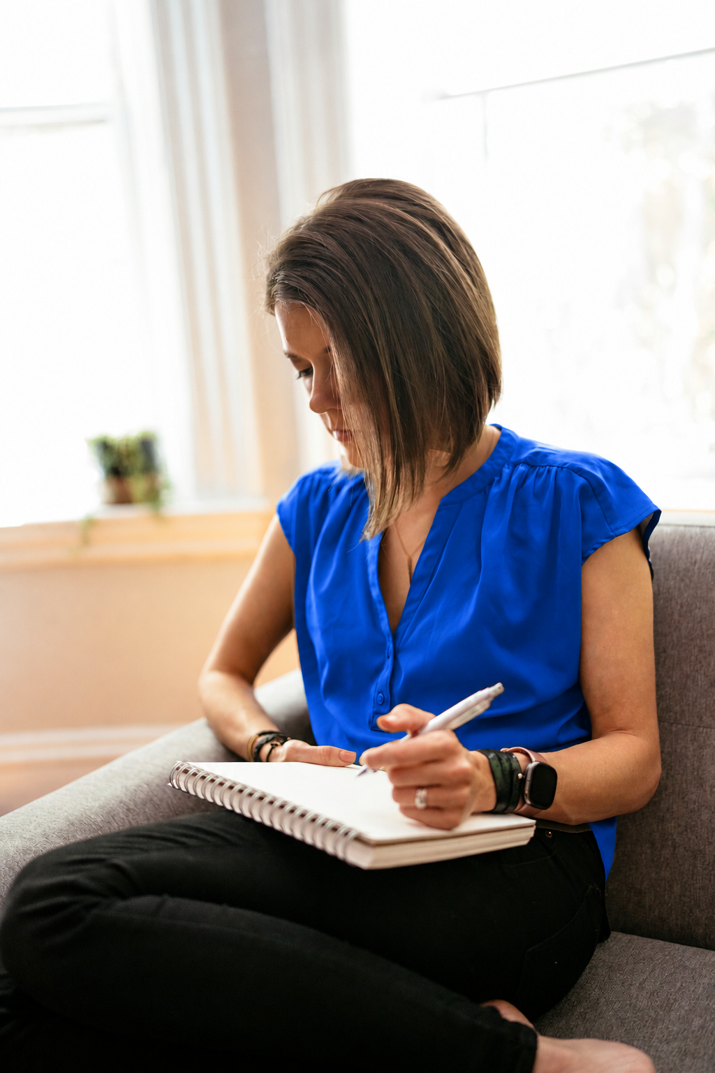 A woman working through ideas in a notebook at home